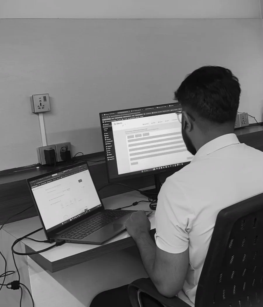 Janak Pokharel working at a dual-monitor desk reviewing an SEO dashboard in Kathmandu, Nepal